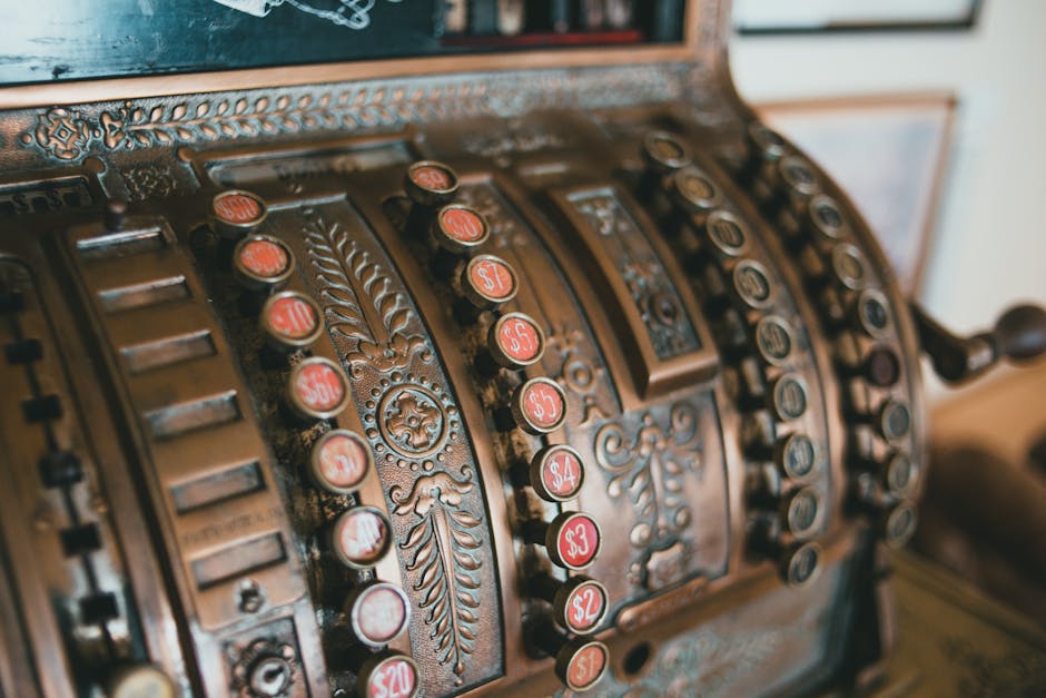 Close-up of an antique brass cash register showcasing vintage design and technology.